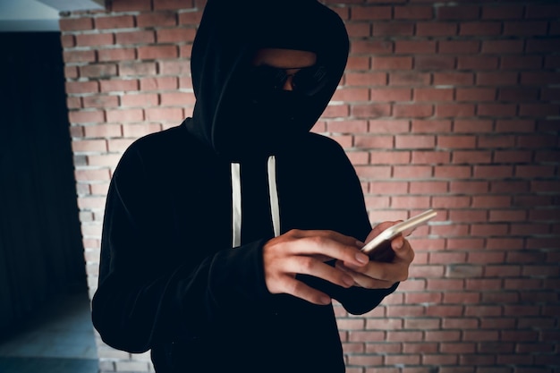 Criminoso com o telemóvel contra a parede