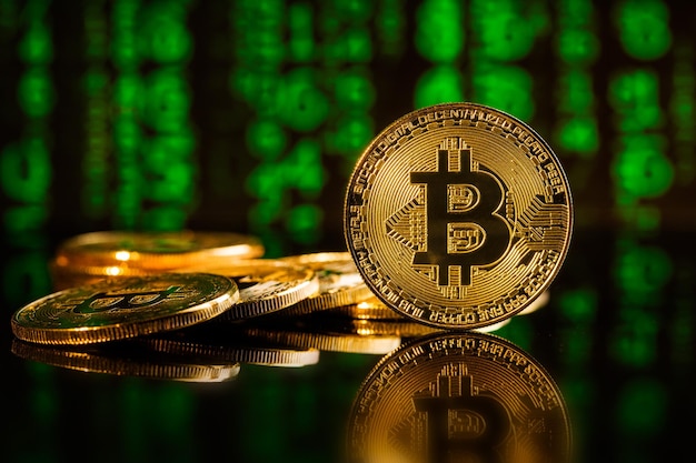 Criptomoneda bitcoins dorados frente a un fondo de matriz verde