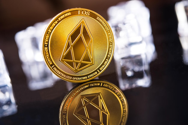 Criptomoneda EOS dorada sobre fondo oscuro con cubitos de hielo