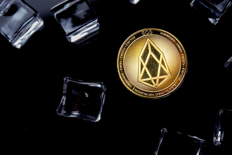 Foto criptomoneda eos dorada sobre fondo oscuro con cubitos de hielo