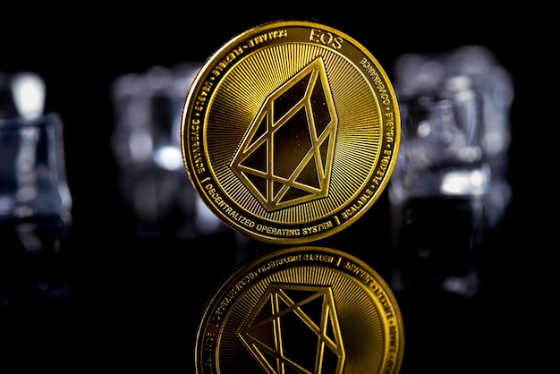 Criptomoneda EOS dorada sobre fondo oscuro con cubitos de hielo