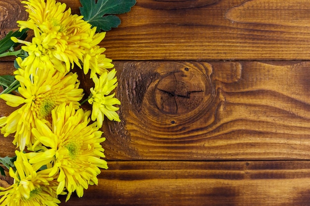 Crisantemos amarillos sobre fondo de madera Vista superior copia espacio