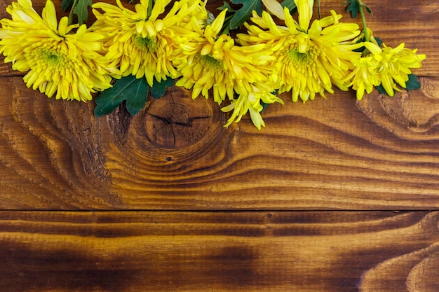 Crisantemos amarillos sobre fondo de madera Vista superior copia espacio