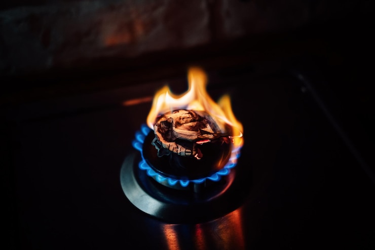 Foto crisis energética después de la invasión rusa de ucrania aumento del costo del pago del suministro de gas natural billete de papel quemado como combustible en el quemador de la estufa de gas en la cocina