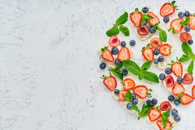 Crispbread de la subida con concepto colorido de las bayas y de las frutas en la opinión superior del espacio en colores pastel de la copia del fondo