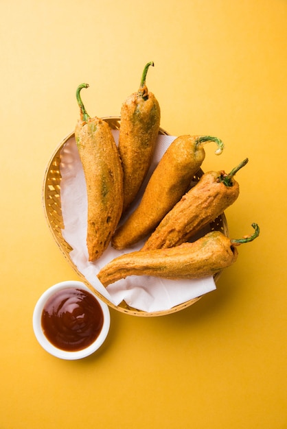 Crispy Green Chilli Pakora o Mirchi Bajji, servido con salsa de tomate sobre un fondo de mal humor. Es un bocadillo popular para la hora del té en la India, especialmente en Monzón. Enfoque selectivo