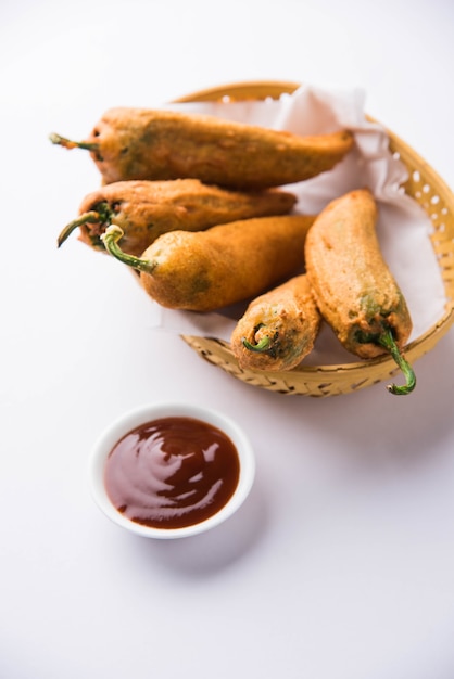 Crispy Green Chilli Pakora o Mirchi Bajji, servido con salsa de tomate sobre un fondo de mal humor. Es un bocadillo popular para la hora del té en la India, especialmente en Monzón. Enfoque selectivo