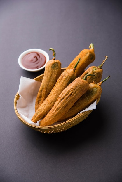 Crispy Green Chilli Pakora o Mirchi Bajji, servido con salsa de tomate sobre un fondo de mal humor. Es un bocadillo popular para la hora del té en la India, especialmente en Monzón. Enfoque selectivo