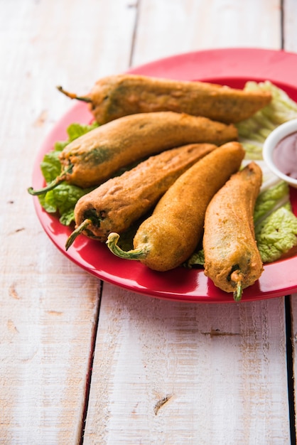 Crispy Green Chilli Pakora o Mirchi Bajji, servido con salsa de tomate sobre un fondo de mal humor. Es un bocadillo popular para la hora del té en la India, especialmente en Monzón. Enfoque selectivo