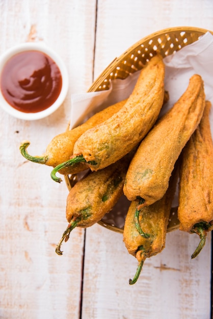 Crispy Green Chilli Pakora o Mirchi Bajji, servido con salsa de tomate sobre un fondo de mal humor. Es un bocadillo popular para la hora del té en la India, especialmente en Monzón. Enfoque selectivo