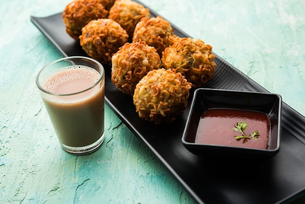 Crispy Noodles Pakora o pakoda es una popular comida callejera indochina que se sirve con salsa de tomate