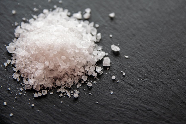 Foto cristais brancos de sal para alimentos em fundo preto