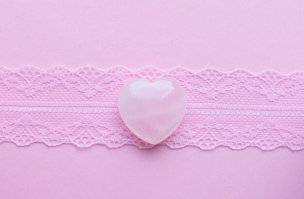 Cristais de quartzo rosa em forma de coração em renda rosa Minerais semipreciosos são um talismã de amor para as mulheres
