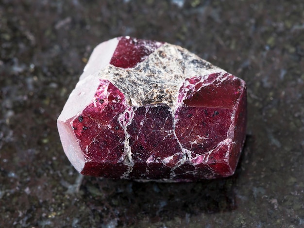 Cristal en bruto de piedras preciosas de granate rojo en la oscuridad