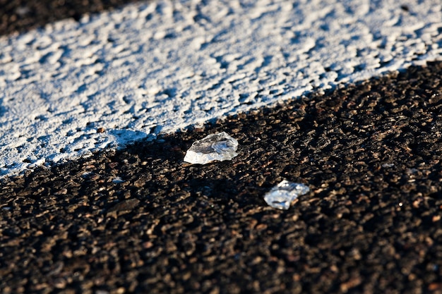 El cristal de un coche abandonado en la acera tras el accidente.