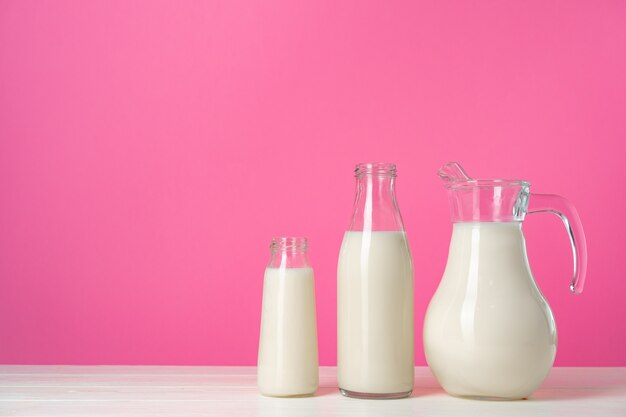 Cristalería con leche fresca contra rosa pastel