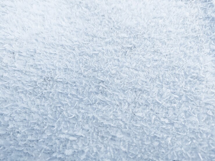 Cristales de hielo, heladas de primer plano en la mañana, fondo escarchado, escarcha en el suelo. Estructura de escarcha de nieve. Centrarse en el centro.