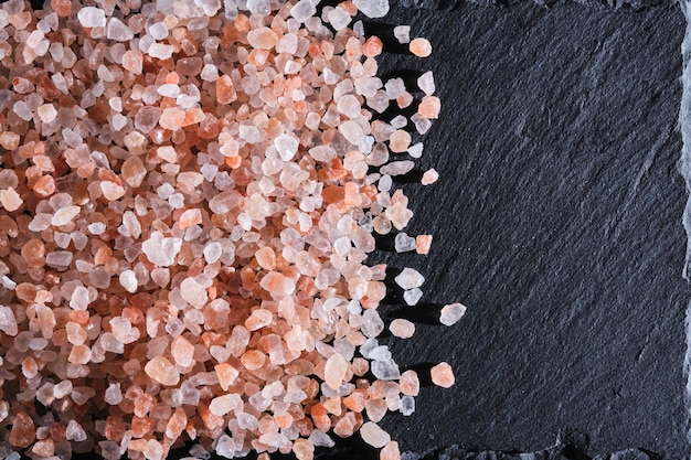 Cristalos de sal rosa comestível do Himalaia em fundo de pedra de ardósia