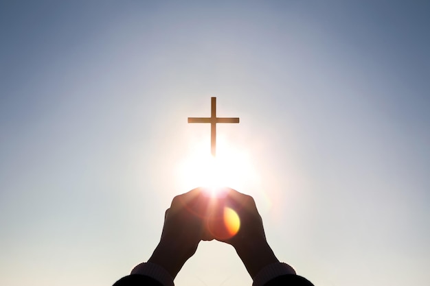 Foto cristiano sosteniendo la cruz de jesucristo en ambas manos