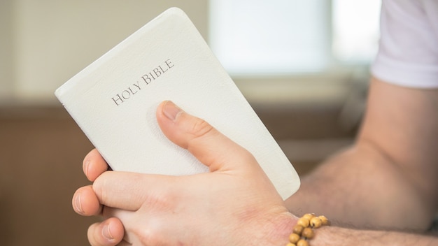 El cristiano tiene la Biblia en sus manos. Leyendo la biblia. El concepto de fe, espiritualidad y religión.