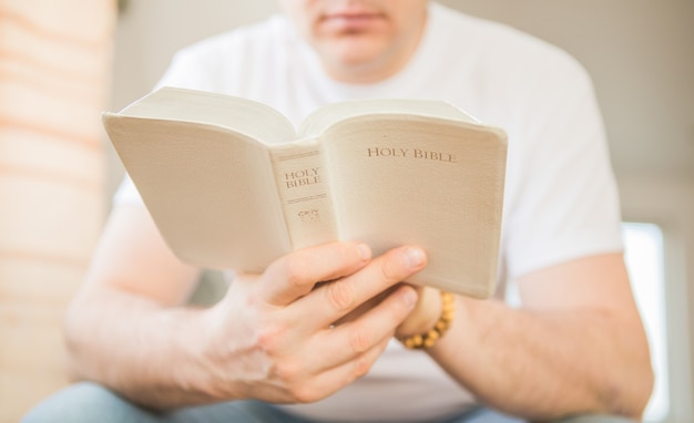 El cristiano tiene la Biblia en sus manos. Leyendo la biblia. El concepto de fe, espiritualidad y religión.
