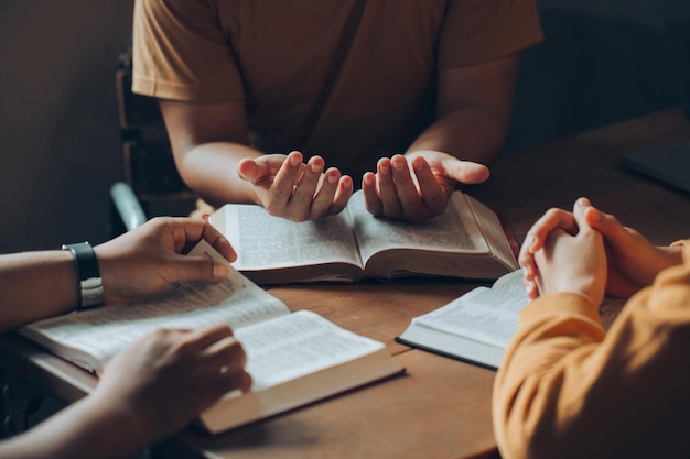Cristianos y concepto de estudio de la Biblia Familia Christi sentada alrededor de una mesa de madera con una biblia abierta