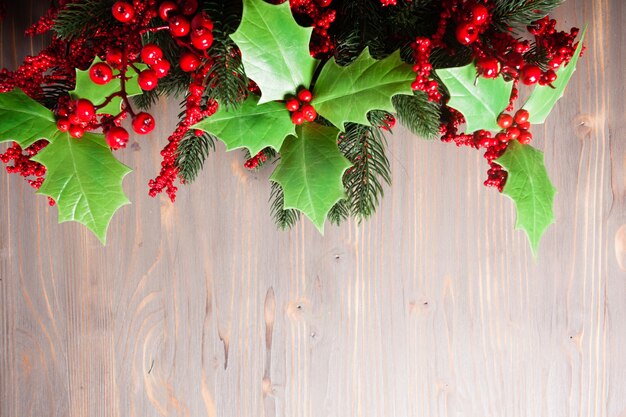 Cristmas Holly berry y ramitas de abeto en el gris