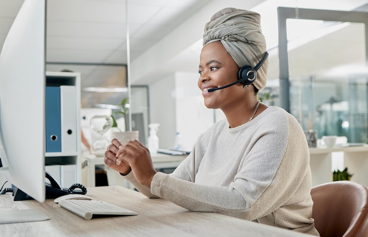 Foto crm contáctenos o una mujer negra en el centro de atención al cliente para una agencia de comunicación o telemercadeo micrófono de computadora o consultor africano hablando ayudando o hablando en el escritorio de la oficina