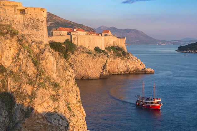 Croácia. Dalmácia do Sul. Vista aérea de Dubrovnik, cidade murada medieval e um barco de leitura cruzando o mar