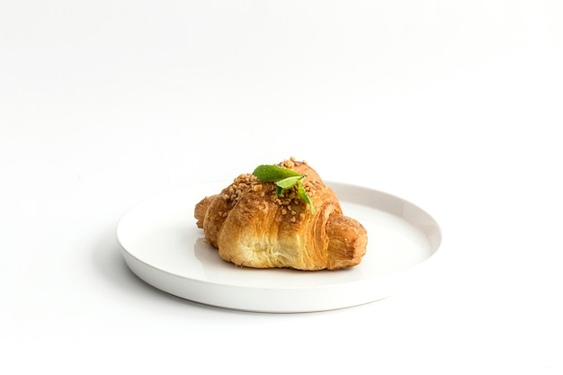 Croissant con almendras en el fondo blanco