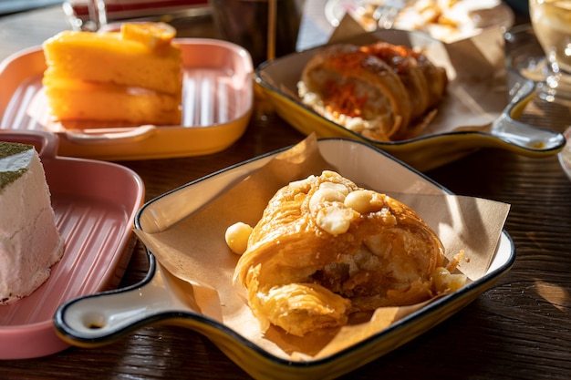 Croissant de almendras marrón dorado y crujiente desayuno francés servido en una bandeja sobre la mesa de madera