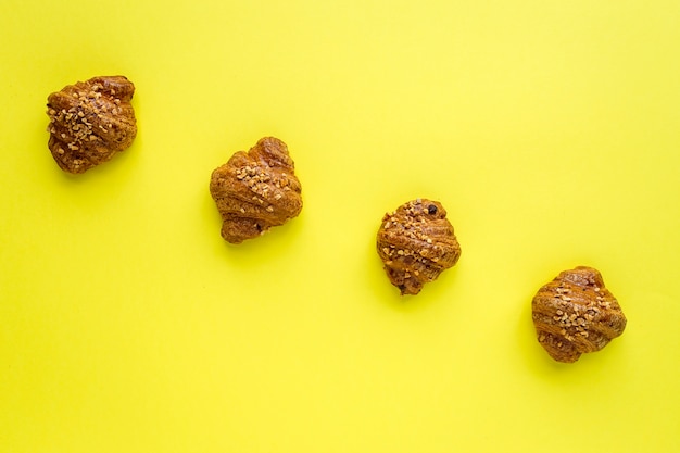 Croissant con almendras sobre fondo amarillo