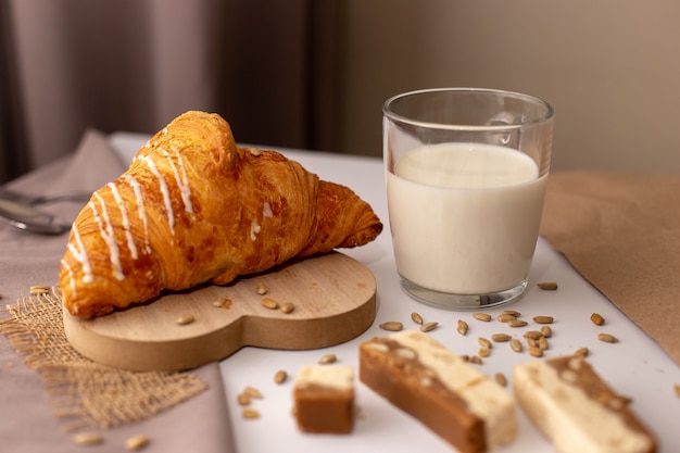 Croissant apetitoso, um copo de leite e fatias de sorvete doce. Café da manhã saboroso
