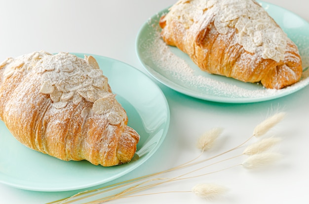 croissant con azúcar en polvo y hojuelas de almendras