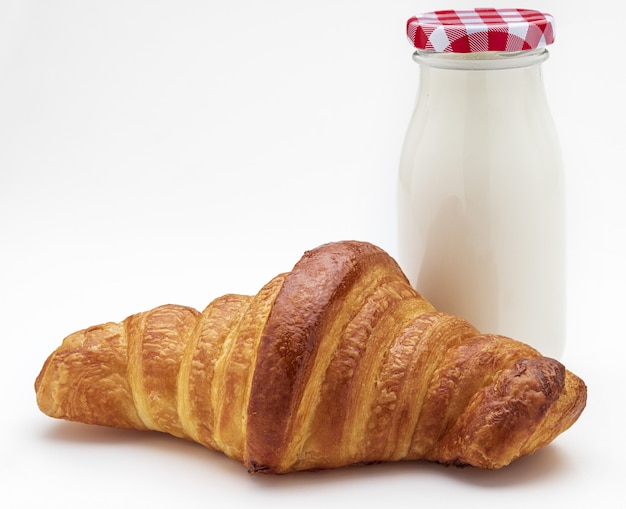 Foto croissant y botella de leche para el desayuno.