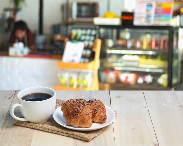 Croissant y café en la mesa de madera