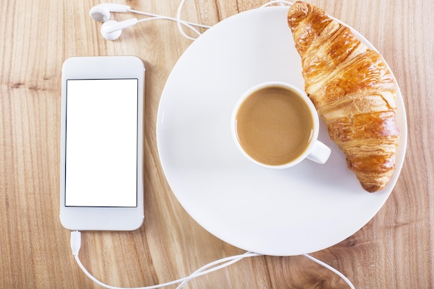 Croissant y café de teléfono inteligente blanco