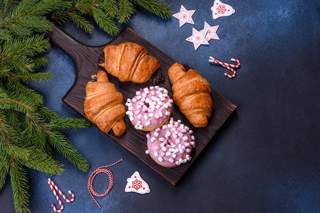 Croissant de chocolate crujiente con adornos navideños en tabla de cortar de madera