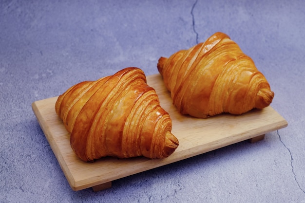 Croissant clássico de manteiga em placa de madeira