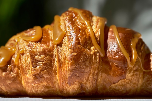 Croissant com caramelo e nozes. luz forte. fundo branco. textura, close-up, foco seletivo