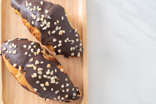 Croissant com chocolate e noz no prato de madeira