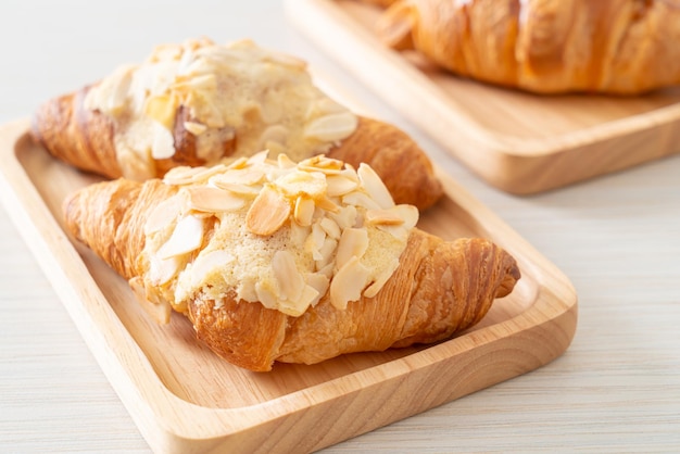 croissant com creme e amêndoas no prato de madeira