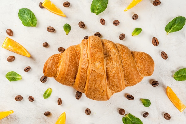 Croissant com grãos de café, laranjas e folhas de hortelã