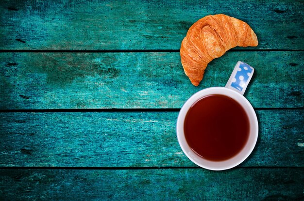 Foto croissant com o chá na mesa