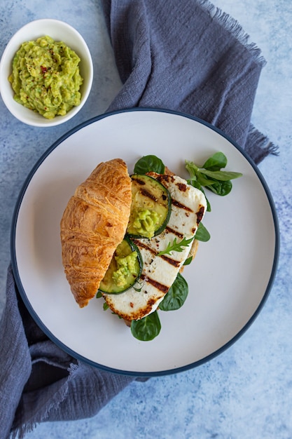 Croissant com queijo halloumi grelhado, rúcula e abobrinha grelhada. Café da manhã ou almoço saudável.