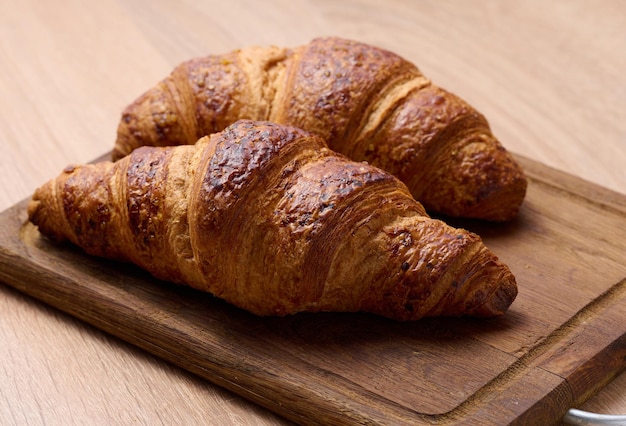 Croissant crocante assado em uma placa de madeira breakfastx9