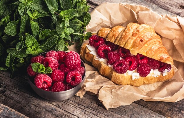 Foto croissant crocante delicioso com framboesas frescas e ricota