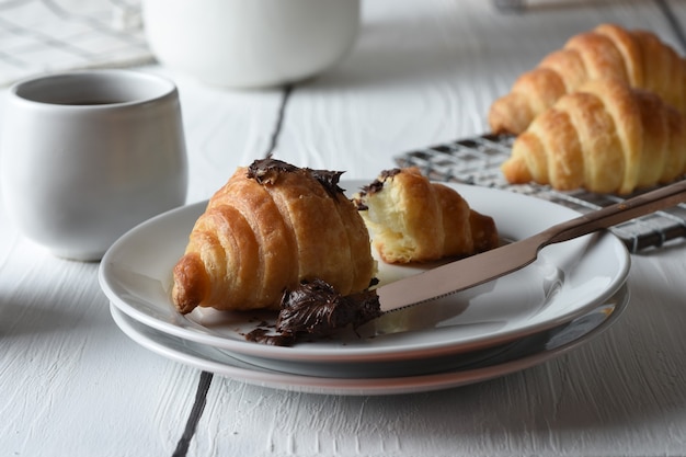 croissant Croissants frescos assados em uma bandeja com um pequeno pote de geleia para o café da manhã