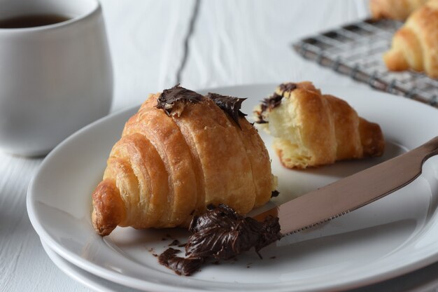 Foto croissant croissants frescos assados em uma bandeja com um pequeno pote de geleia para o café da manhã