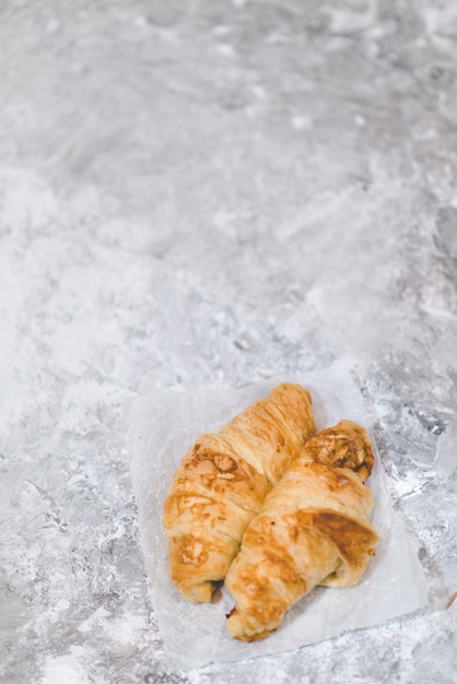 Croissant de massa folhada no café da manhã em um fundo claro